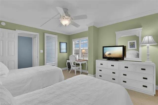 a bedroom with a bed and a flat tv screen on dresser