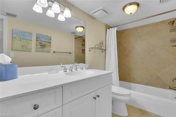 a bathroom with a sink a toilet and a large mirror
