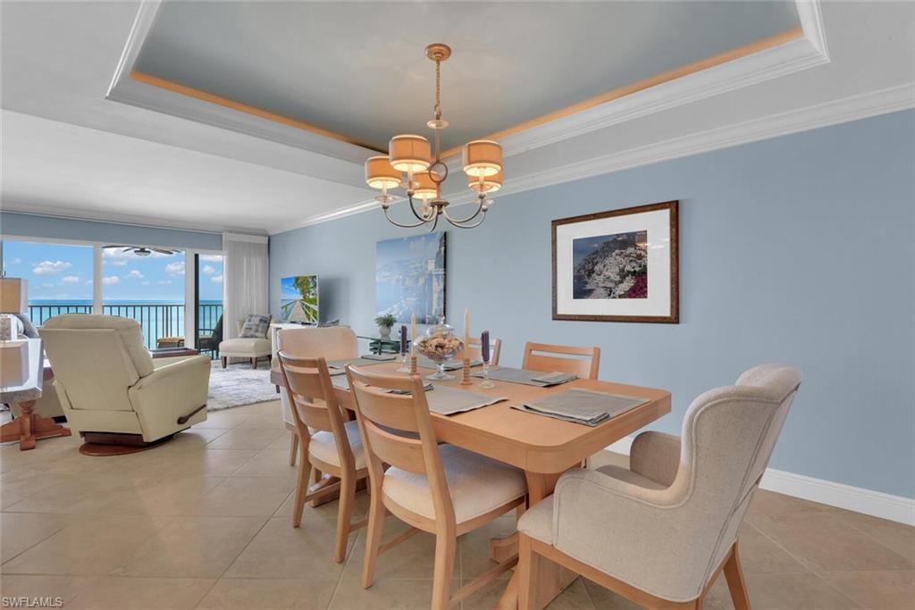 3443 Gulf Shore Boulevard North, Unit 710 Naples, FL 34103 - Photo 6 of 29 a view of a dining room with furniture and chandelier