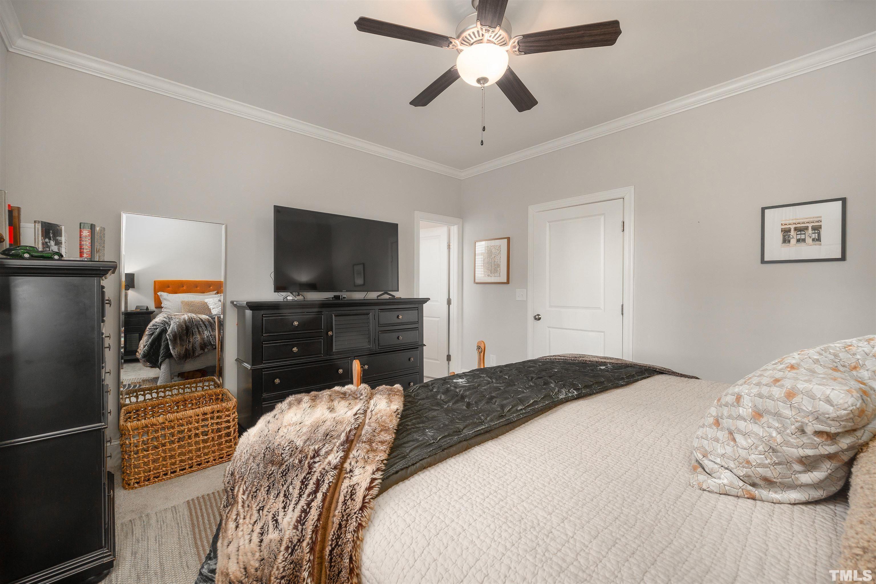 2829 Plumfield Place Raleigh, NC 27607 - Photo 16 of 26 a bedroom with a bed and a flat tv screen on a dresser