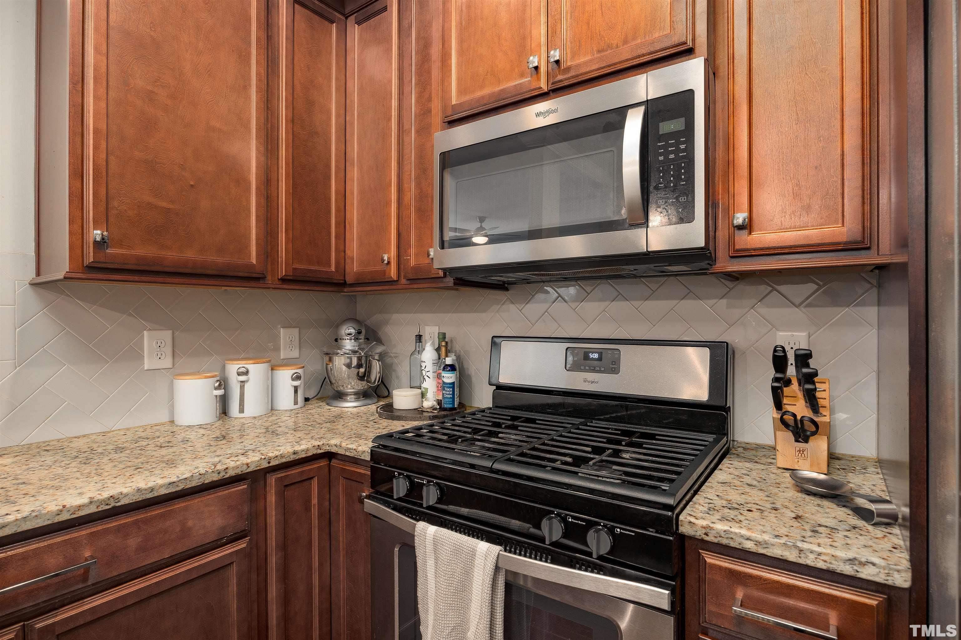 2829 Plumfield Place Raleigh, NC 27607 - Photo 25 of 26 a kitchen with granite countertop a stove top oven cabinetry a sink and dishwasher