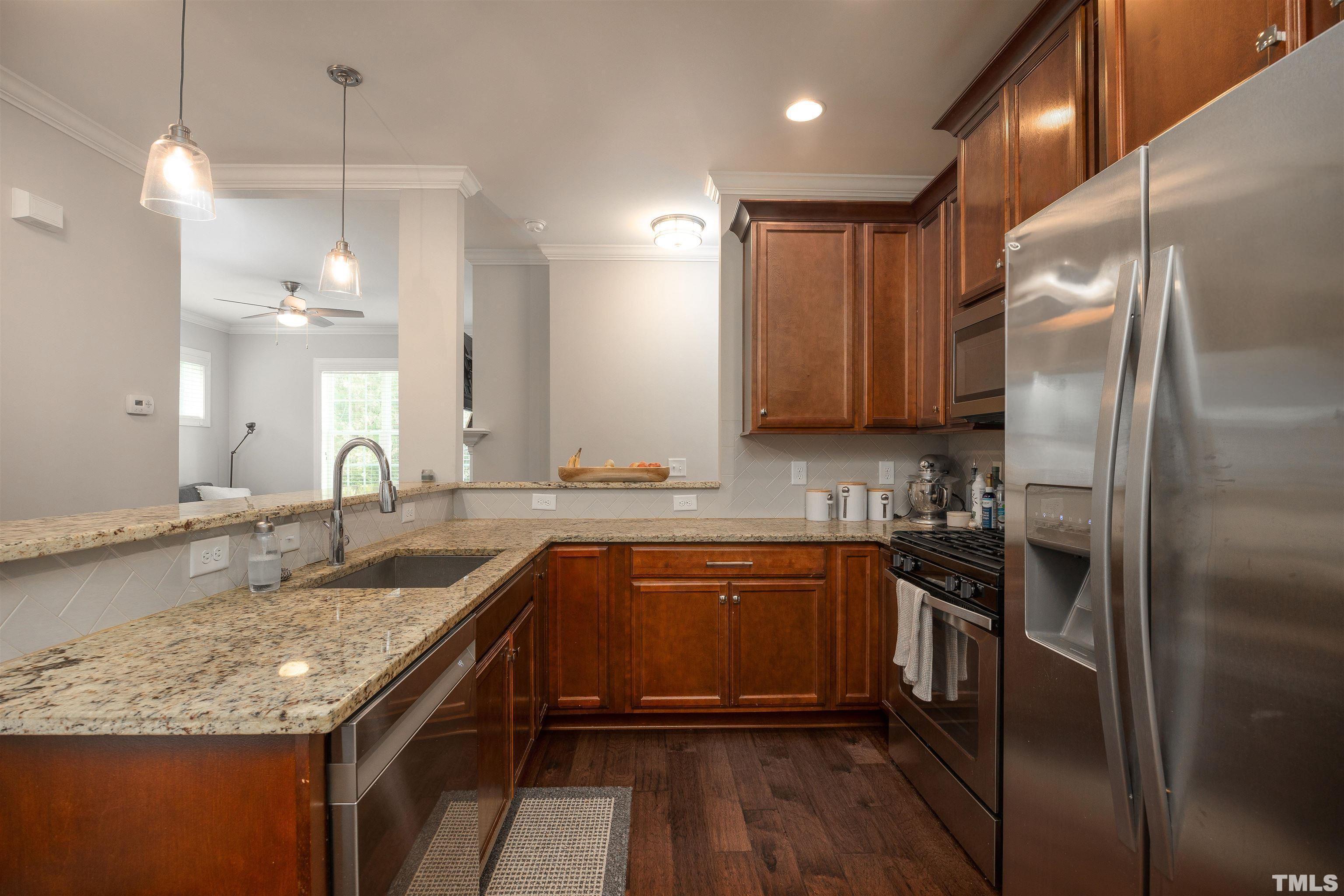 2829 Plumfield Place Raleigh, NC 27607 - Photo 6 of 26 a kitchen with stainless steel appliances granite countertop a sink a stove and a refrigerator