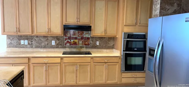 a kitchen with stainless steel appliances granite countertop a refrigerator sink and cabinets