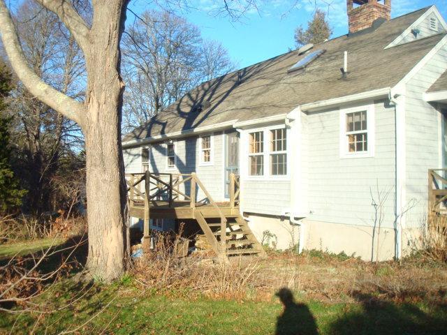 1318 County Road Cataumet, MA 02534 - Photo 2 of 7 a view of a patio with table and chairs and floor to ceiling window with wooden floor