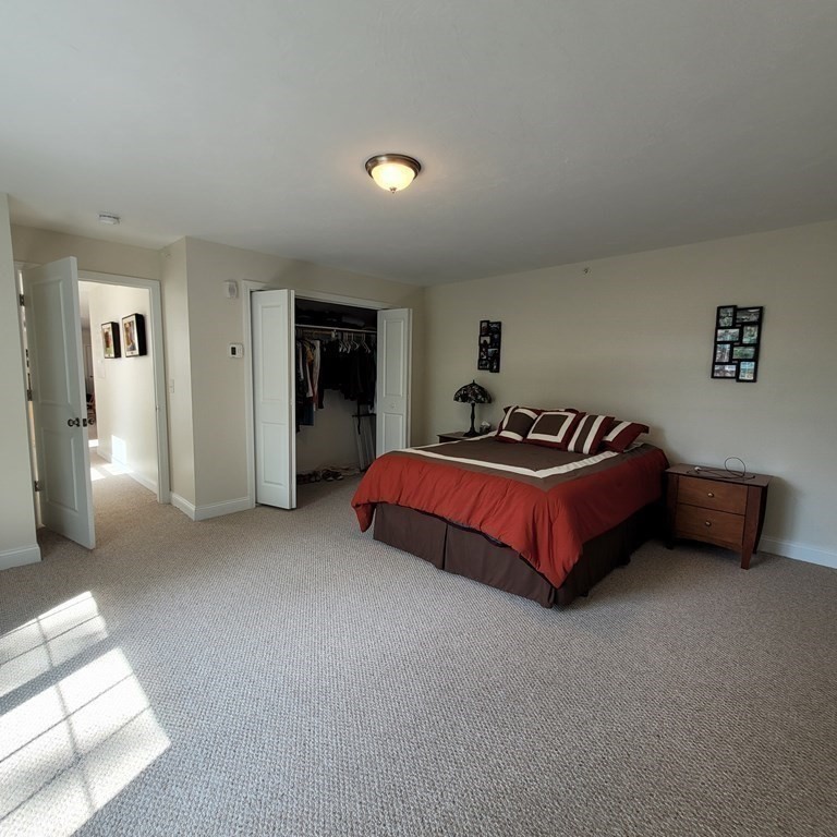 130 Spring Street, Unit 202 Mansfield, MA 02048 - Photo 11 of 23 a spacious bedroom with a bed and closet