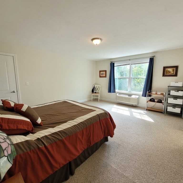 130 Spring Street, Unit 202 Mansfield, MA 02048 - Photo 13 of 23 a bedroom with a bed and a couch