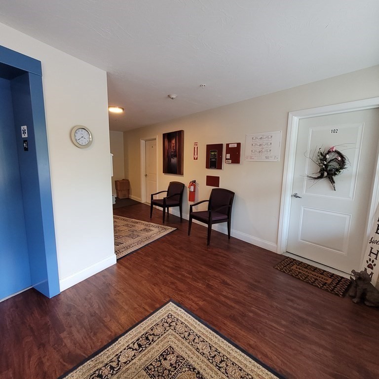 130 Spring Street, Unit 202 Mansfield, MA 02048 - Photo 15 of 23 a living room with furniture and a wooden floor