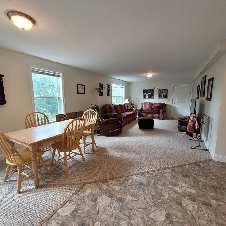 130 Spring Street, Unit 202 Mansfield, MA 02048 - Photo 4 of 23 a living room with furniture a couch and a flat screen tv