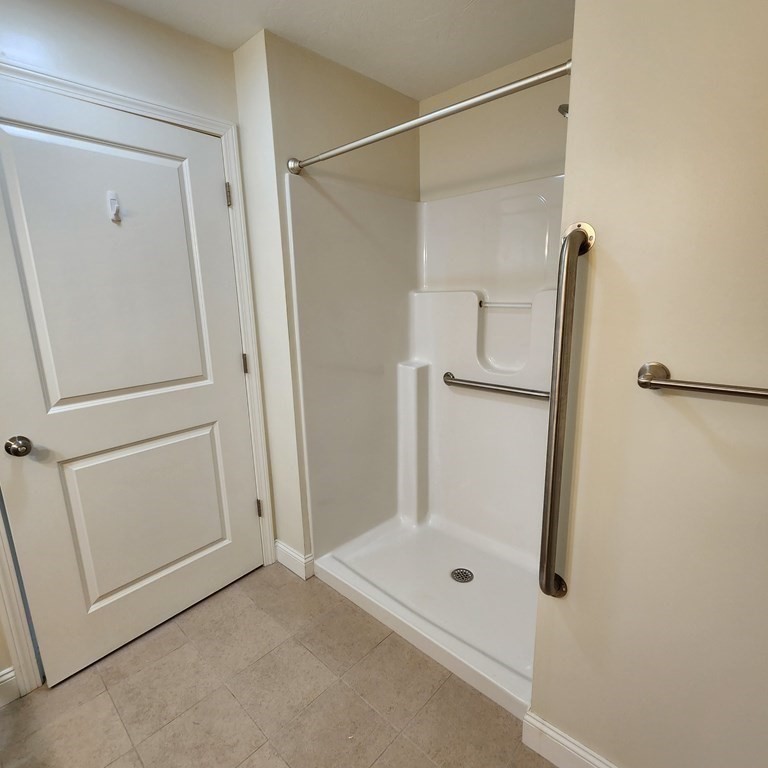 130 Spring Street, Unit 202 Mansfield, MA 02048 - Photo 10 of 23 a bathroom with a glass shower door