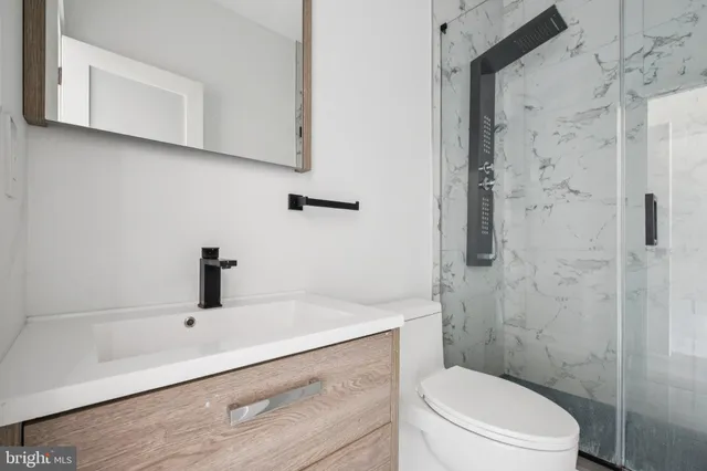 a bathroom with a sink a toilet and shower