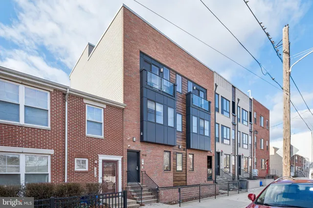 a front view of a building with lot of cars