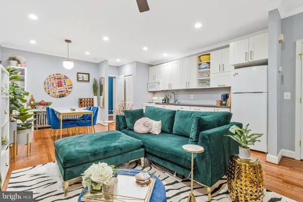 a living room with furniture and a dining table with rug floor