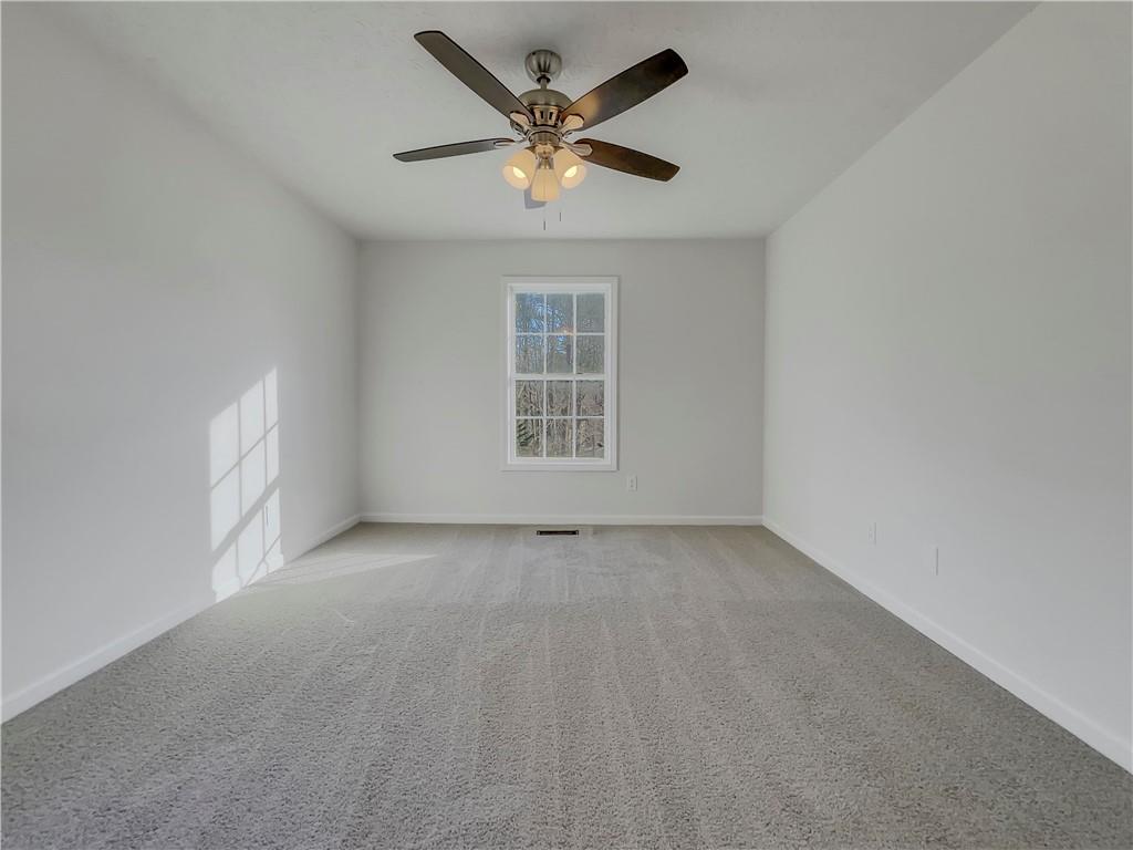 35 Grove Lane Temple, GA 30179 - Photo 14 of 25 an empty room with ceiling fan and windows