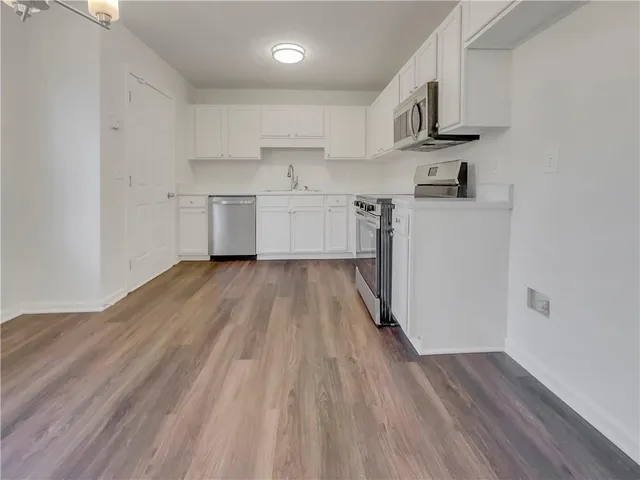 a kitchen with cabinets a sink and wooden floor