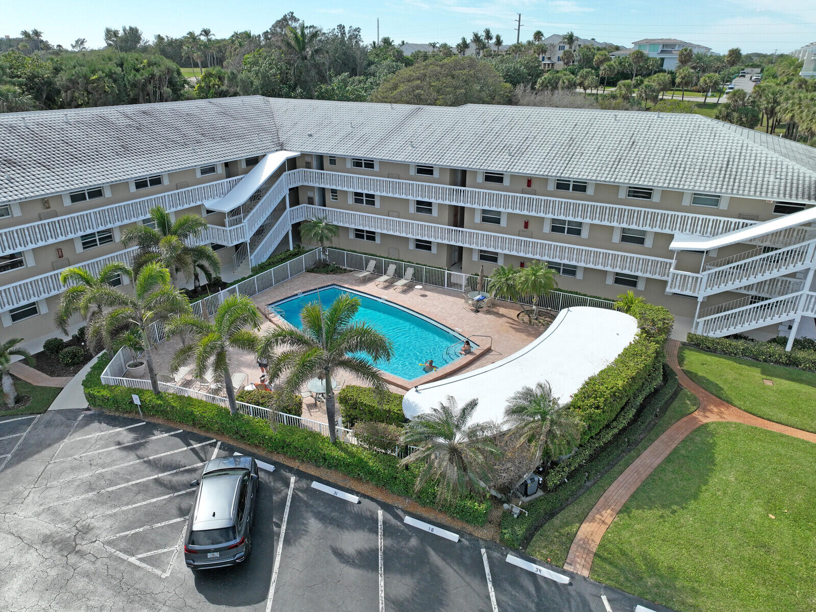 20 Celestial Way, Unit 314 Juno Beach, FL 33408 - Photo 23 of 35 a view of a swimming pool with a patio and a garden