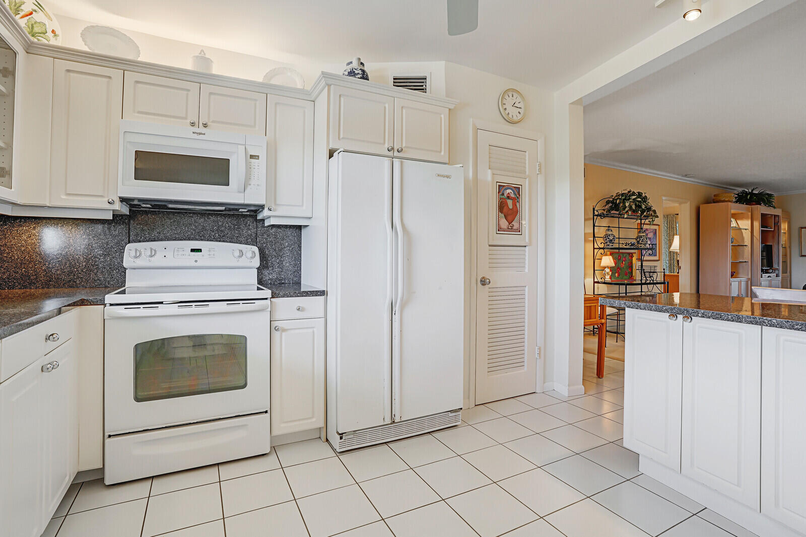 20 Celestial Way, Unit 314 Juno Beach, FL 33408 - Photo 7 of 35 a kitchen with white cabinets and white appliances