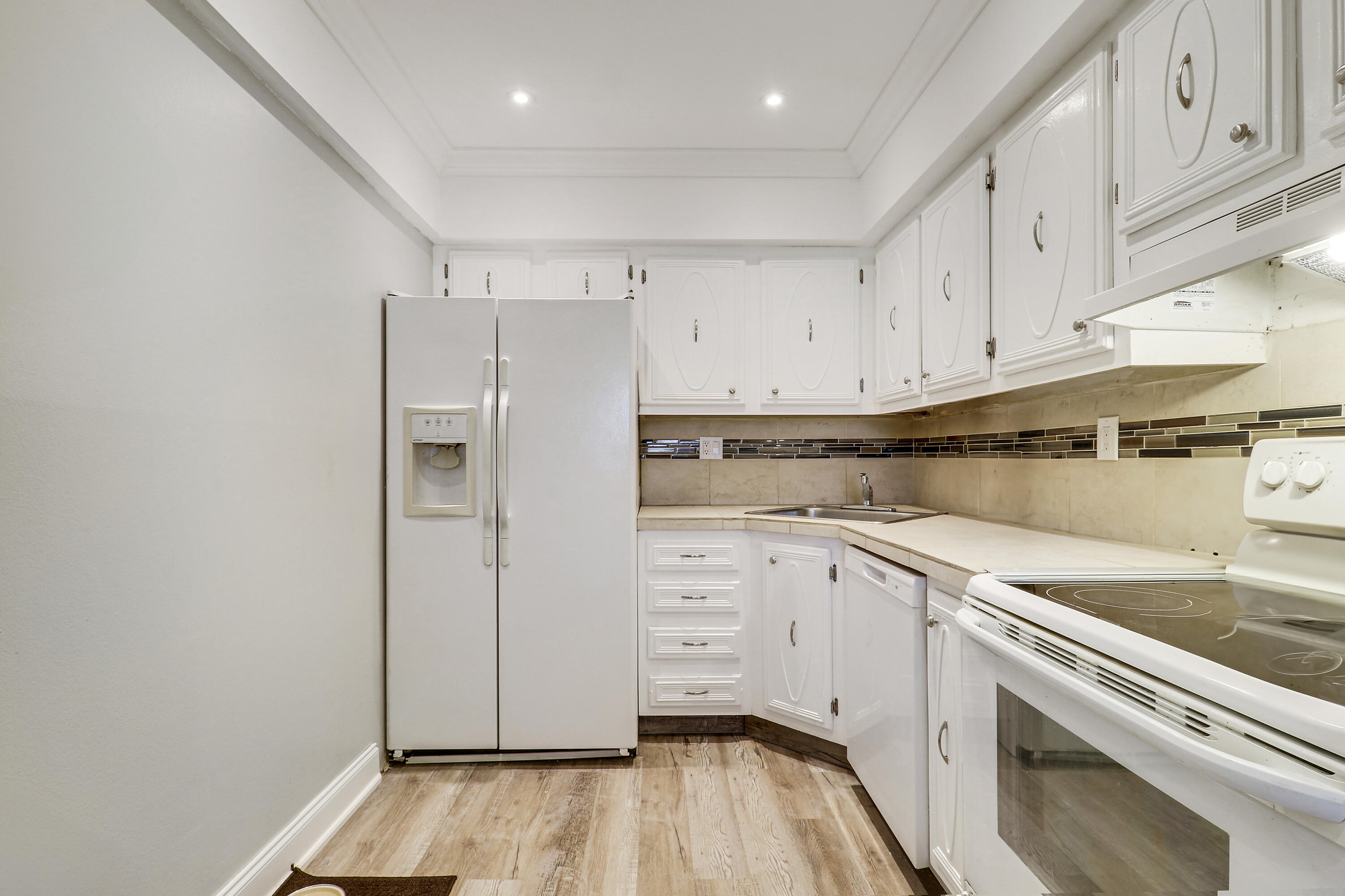 2600 South Kanner Highway, Unit Q8 Stuart, FL 34994 - Photo 15 of 52 a kitchen with white cabinets and white appliances