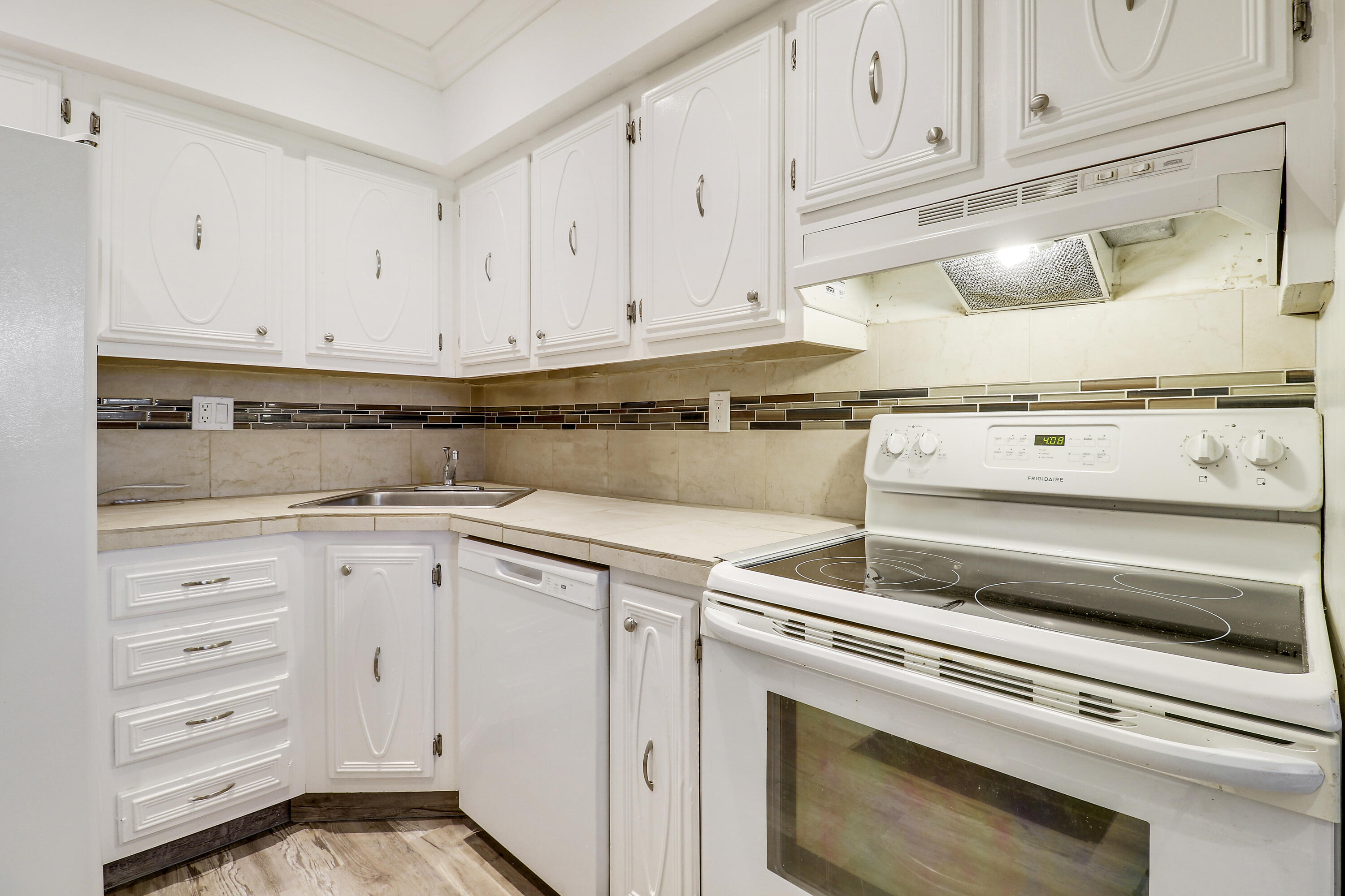 2600 South Kanner Highway, Unit Q8 Stuart, FL 34994 - Photo 16 of 52 a kitchen with white cabinets and white appliances