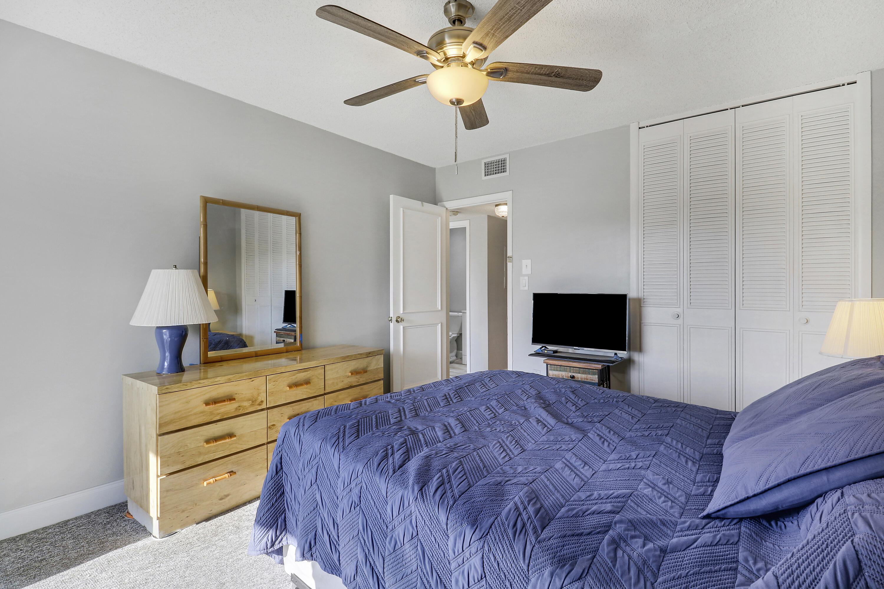 2600 South Kanner Highway, Unit Q8 Stuart, FL 34994 - Photo 18 of 52 a bedroom with a bed and a flat tv screen on dresser