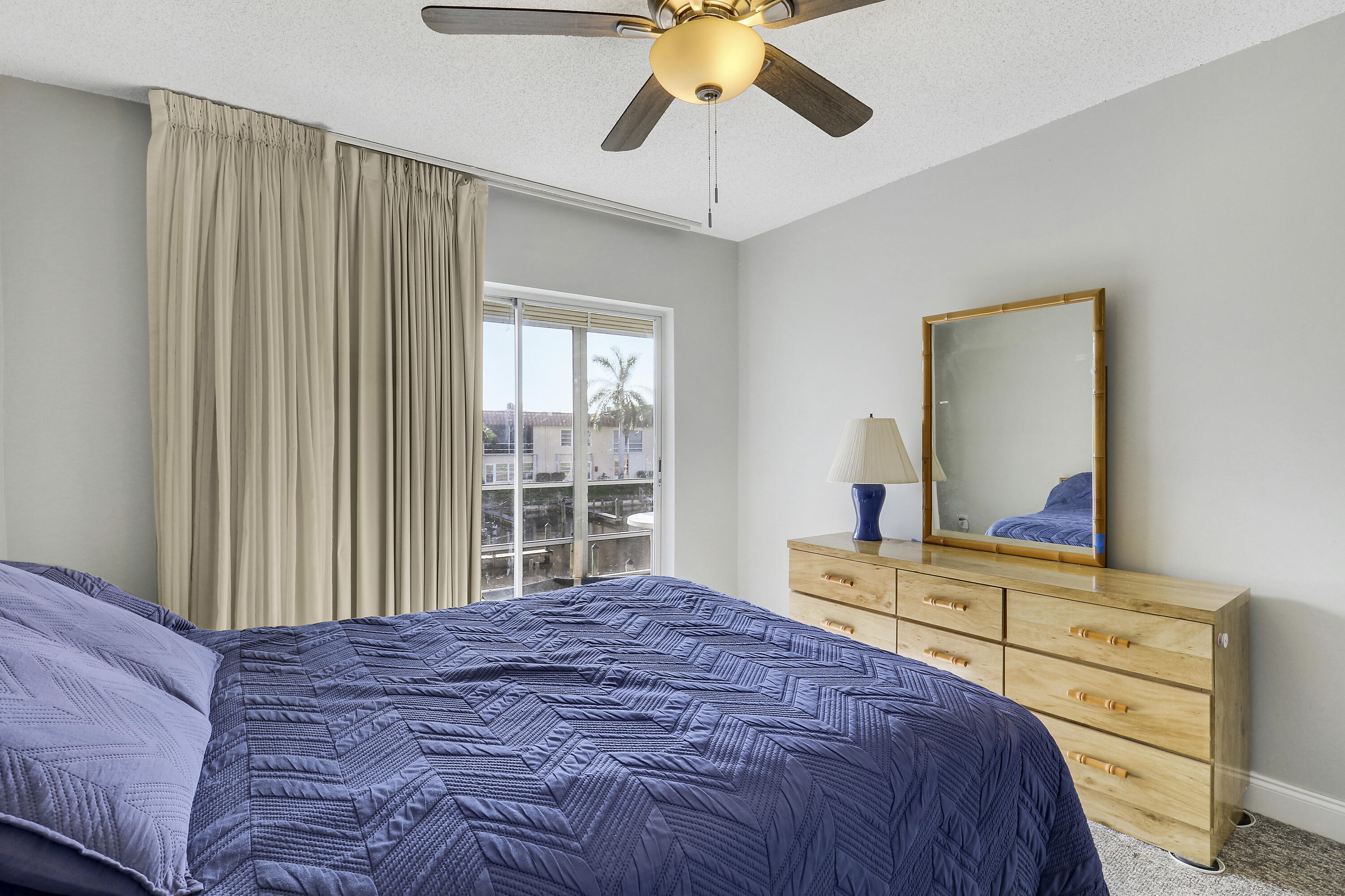 2600 South Kanner Highway, Unit Q8 Stuart, FL 34994 - Photo 19 of 52 a bedroom with a large bed and a chandelier