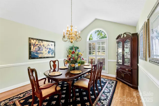 a view of a dining room with furniture a chandelier and wooden floor