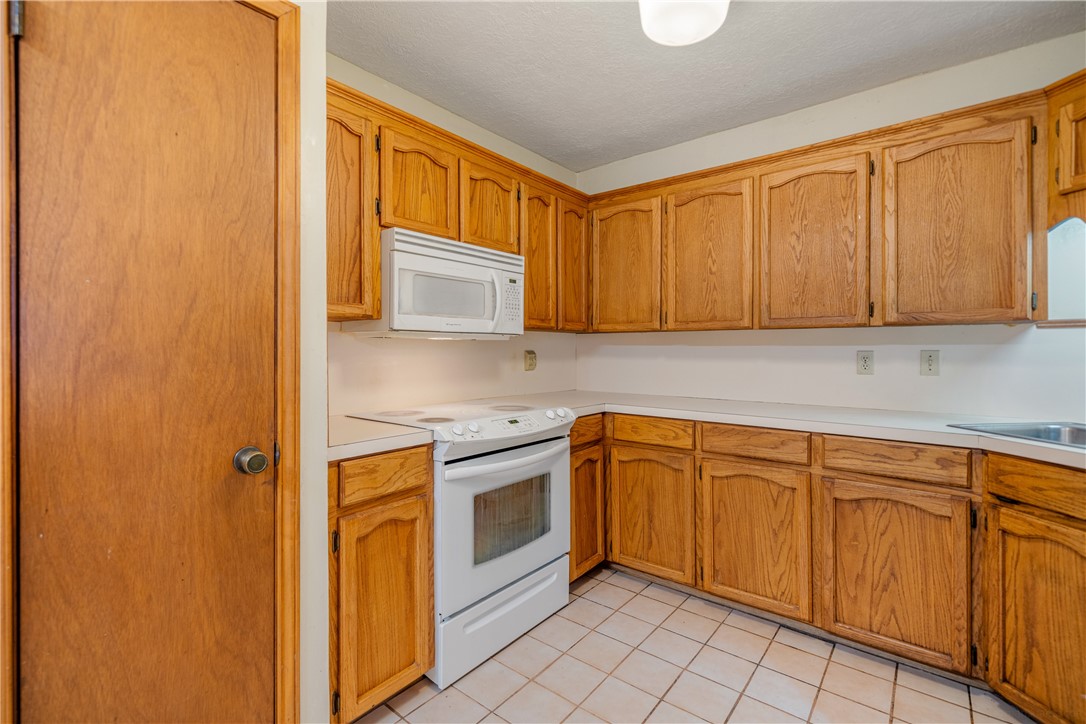 5469 Sunset Trail Robstown, TX 78380 - Photo 13 of 37 a kitchen with stainless steel appliances granite countertop a sink and cabinets with wooden floor