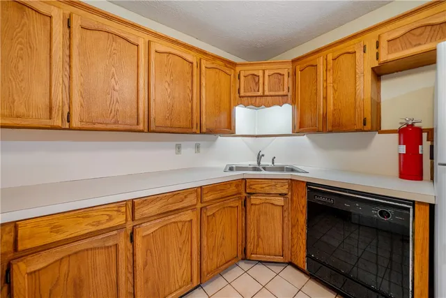 a kitchen with stainless steel appliances granite countertop wooden cabinets a sink and dishwasher