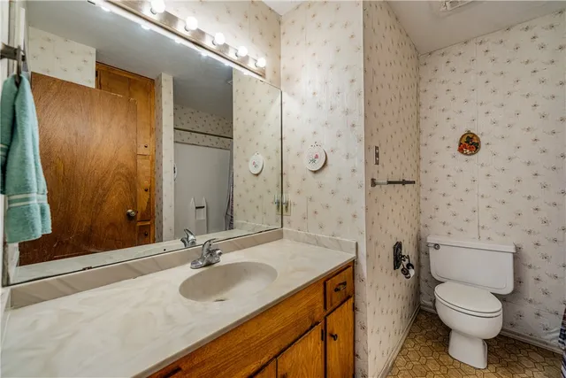 a bathroom with a granite countertop sink toilet and shower