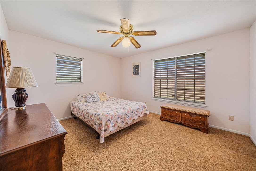 5469 Sunset Trail Robstown, TX 78380 - Photo 22 of 37 a bedroom with a bed a dresser and a window