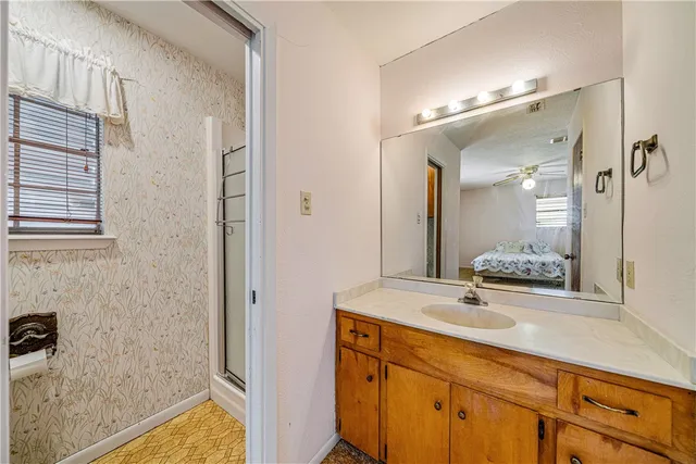 a bathroom with a granite countertop sink and a mirror