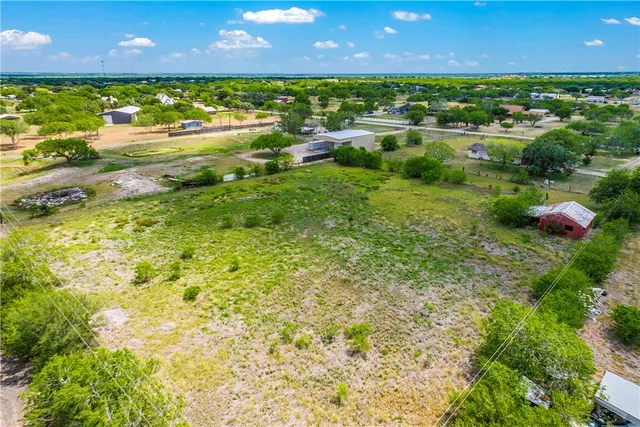 an aerial view of residential houses with outdoor space and swimming pool