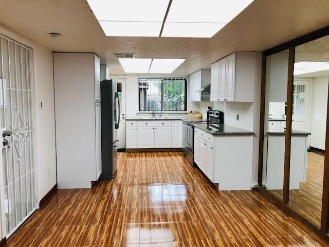 a kitchen with wooden floors and appliances