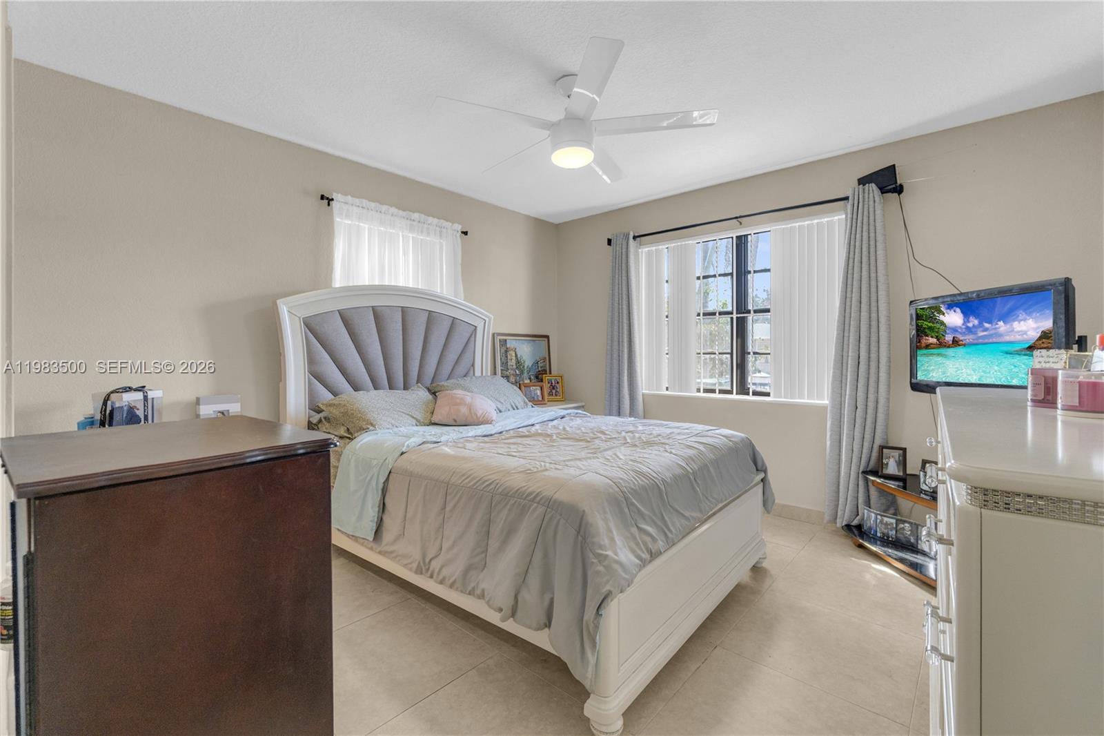 12691 Southwest 190th Street Miami, FL 33177 - Photo 16 of 46 a bedroom with a bed and a flat tv screen on the dresser