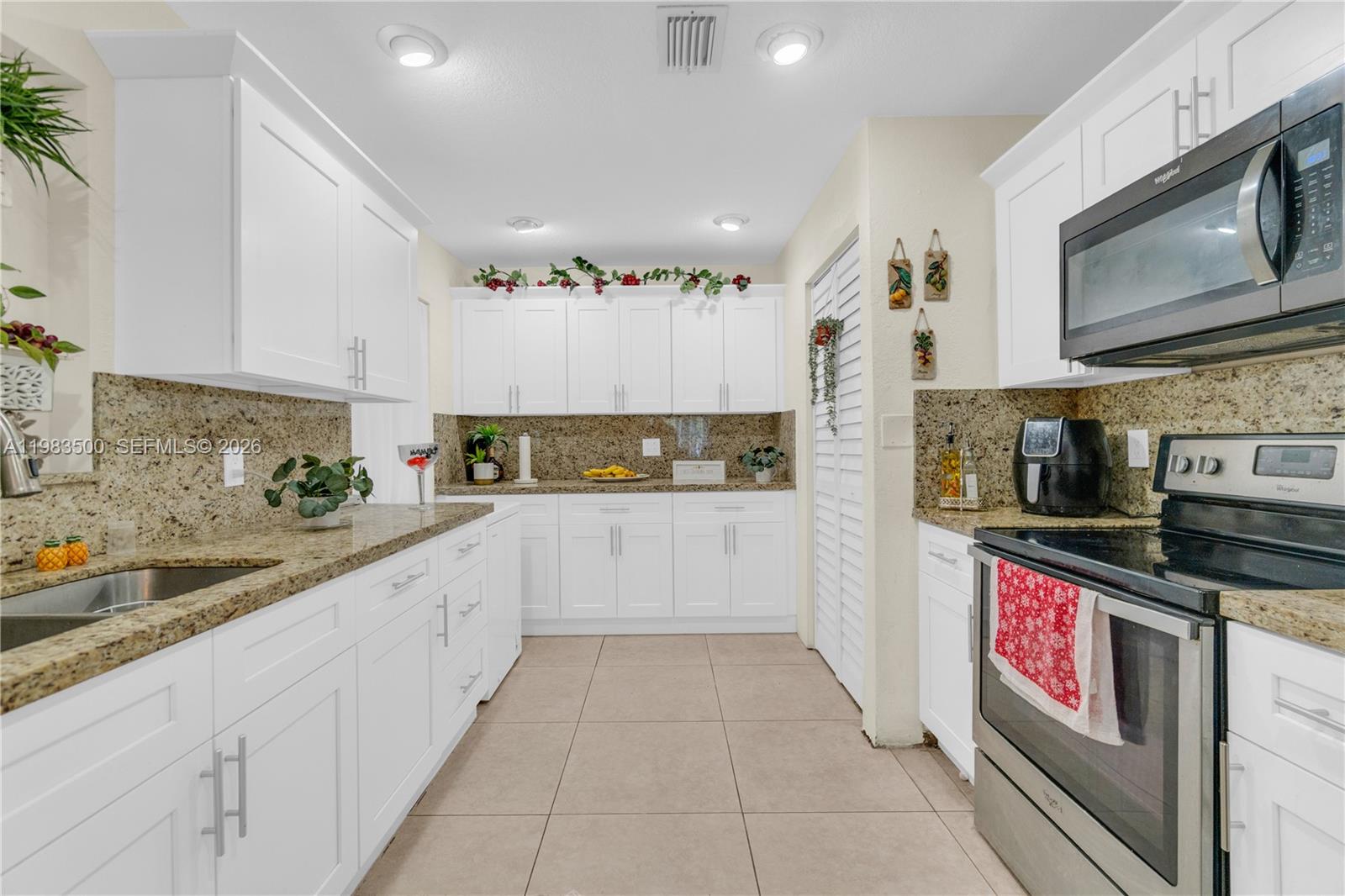 12691 Southwest 190th Street Miami, FL 33177 - Photo 4 of 46 a kitchen with stainless steel appliances granite countertop a sink and cabinets