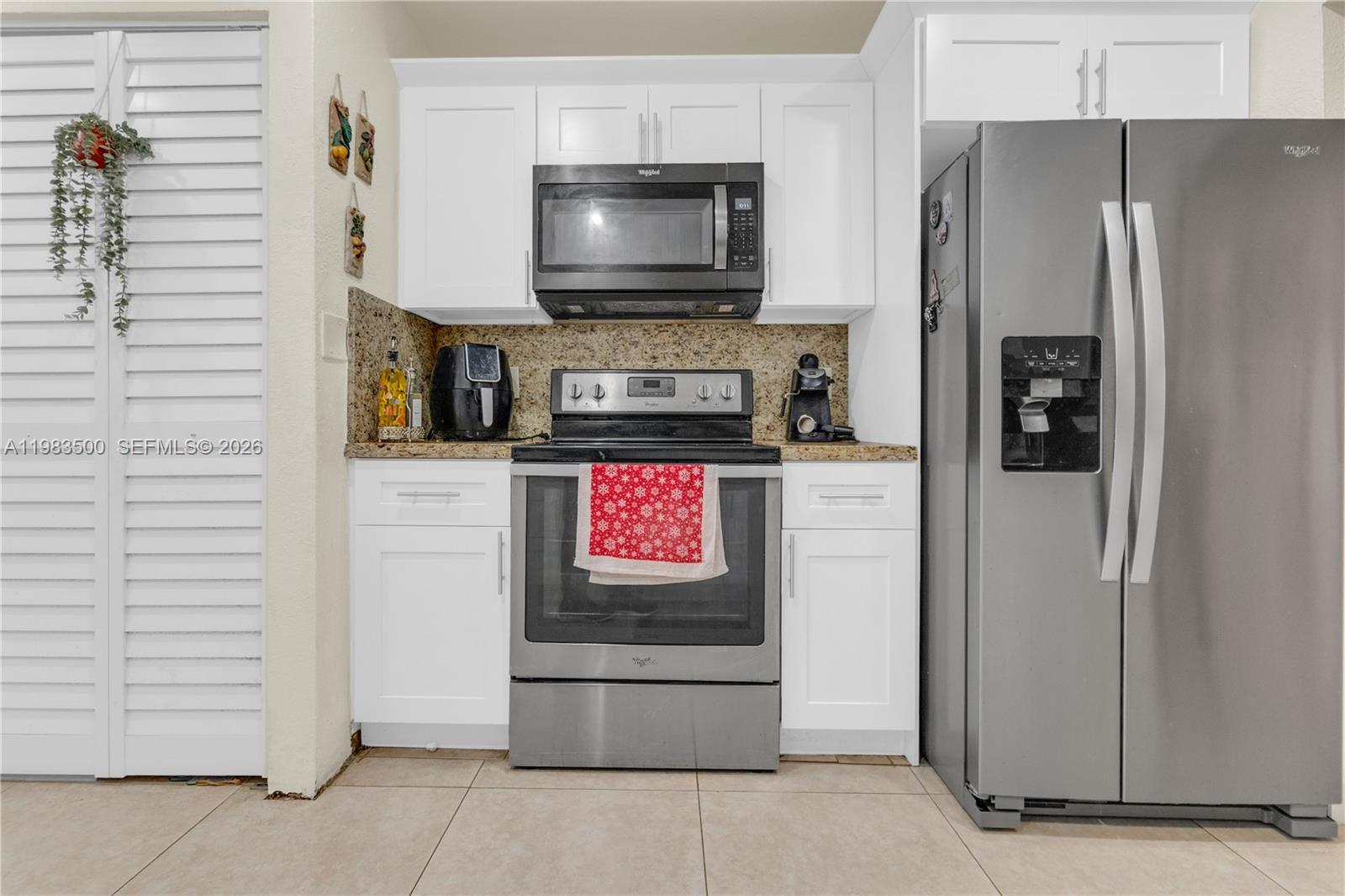 12691 Southwest 190th Street Miami, FL 33177 - Photo 8 of 46 a kitchen with stainless steel appliances a refrigerator a stove and a microwave