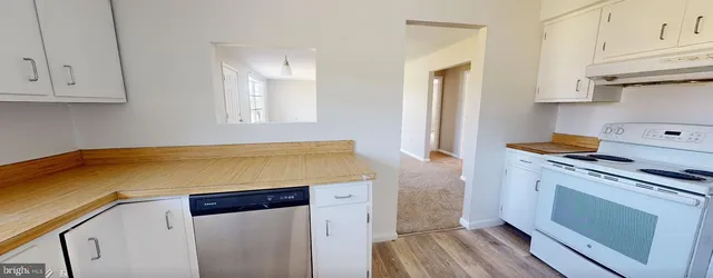 a kitchen with granite countertop white cabinets and white appliances