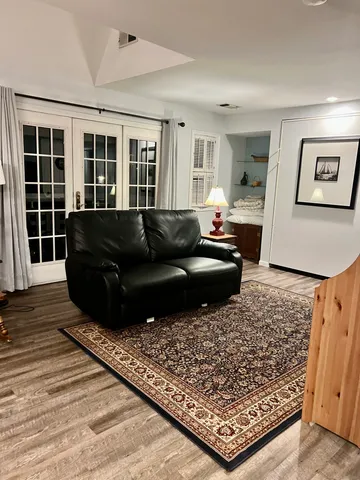 a view of a hallway with wooden floor and a bookshelf