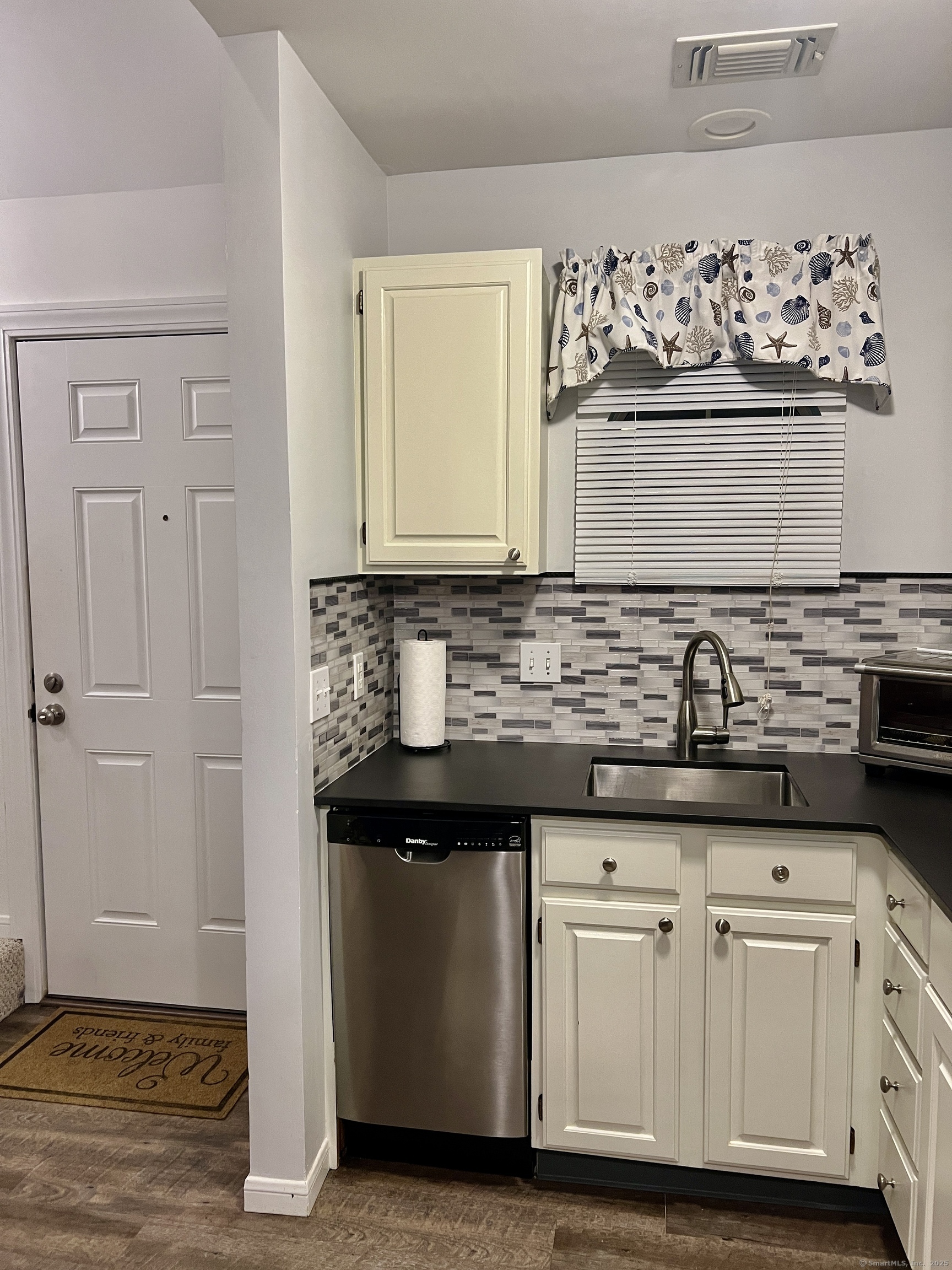 1623 Old Pond Lane, Unit 1623 Norwich, CT 06360 - Photo 4 of 40 a view of cabinets a sink and a stove with wooden floor