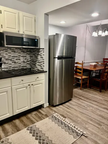 a kitchen with stainless steel appliances granite countertop a refrigerator a stove and a sink with wooden cabinets