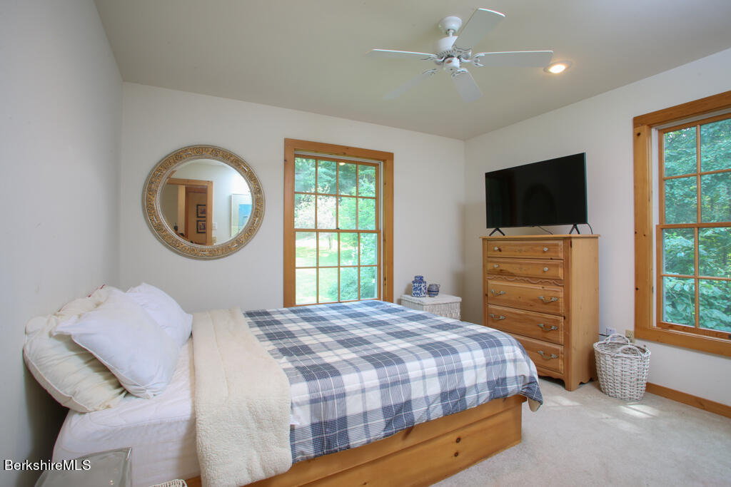 142 Main Road Monterey, MA 01230 - Photo 22 of 32 a bedroom with a bed a dresser and a flat screen tv