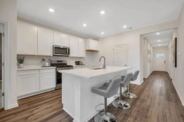 a kitchen with a sink appliances cabinets and furniture