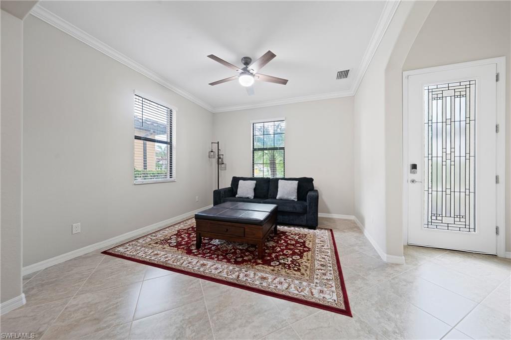 4228 Raffia Palm Circle Naples, FL 34119 - Photo 11 of 50 Living area with ornamental molding, arched walkways, ceiling fan, and light tile patterned floors