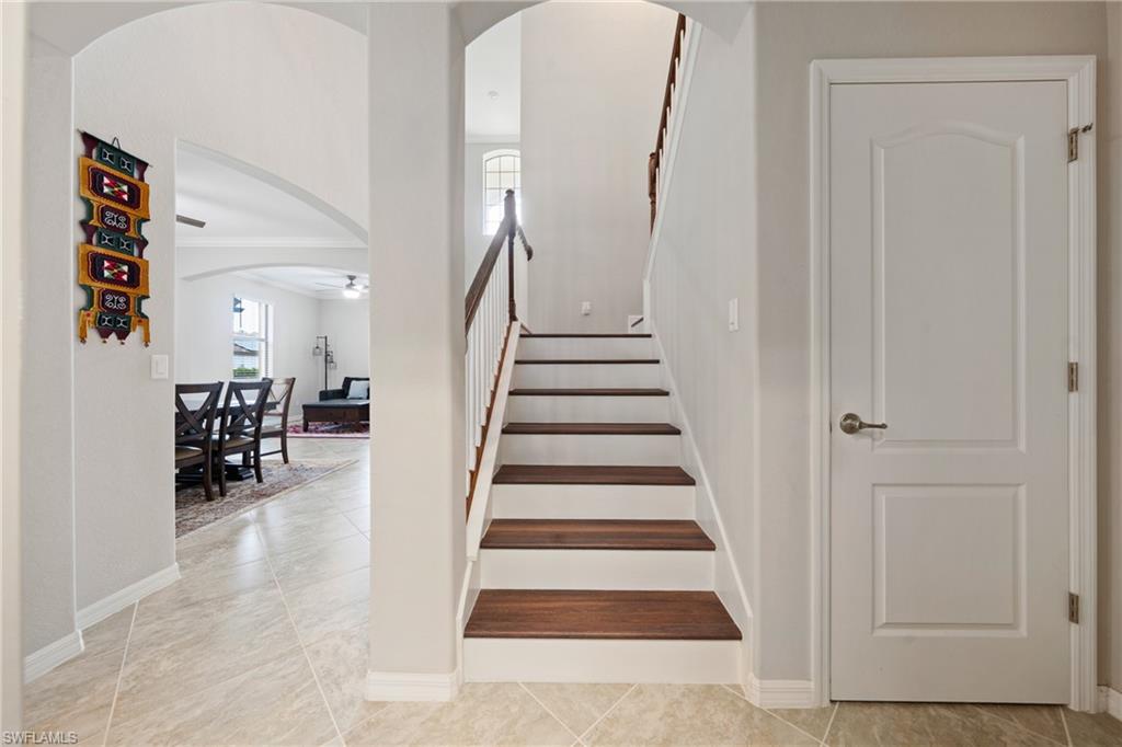 4228 Raffia Palm Circle Naples, FL 34119 - Photo 15 of 50 Stairway featuring arched walkways and tile patterned floors