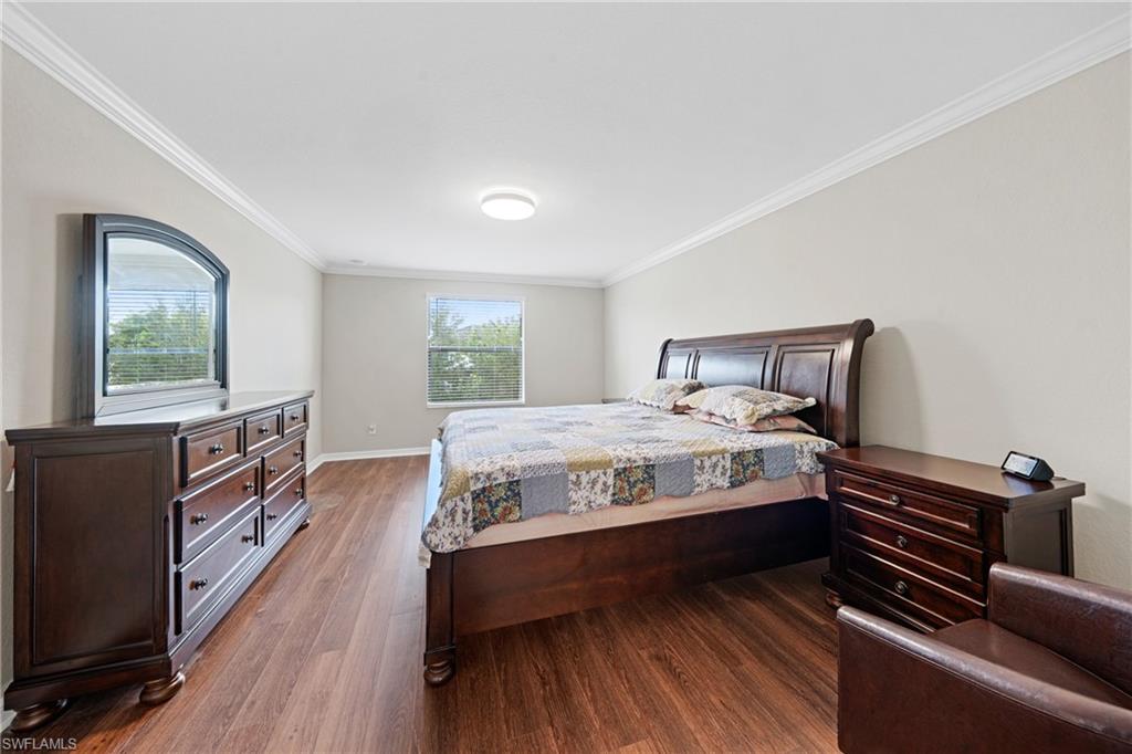 4228 Raffia Palm Circle Naples, FL 34119 - Photo 17 of 50 Bedroom featuring crown molding and dark wood-type flooring