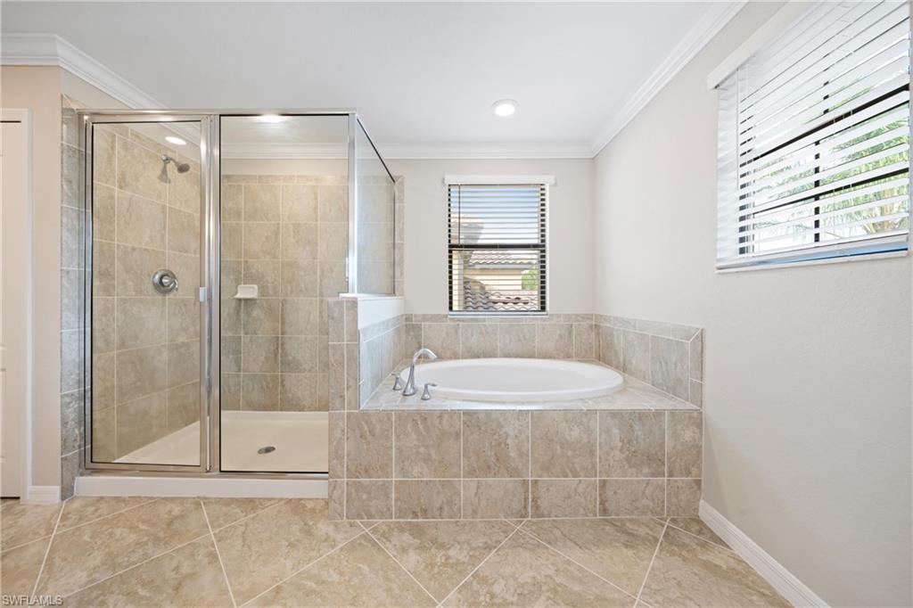 4228 Raffia Palm Circle Naples, FL 34119 - Photo 19 of 50 Bathroom featuring ornamental molding, a bath, a stall shower, and light tile patterned floors