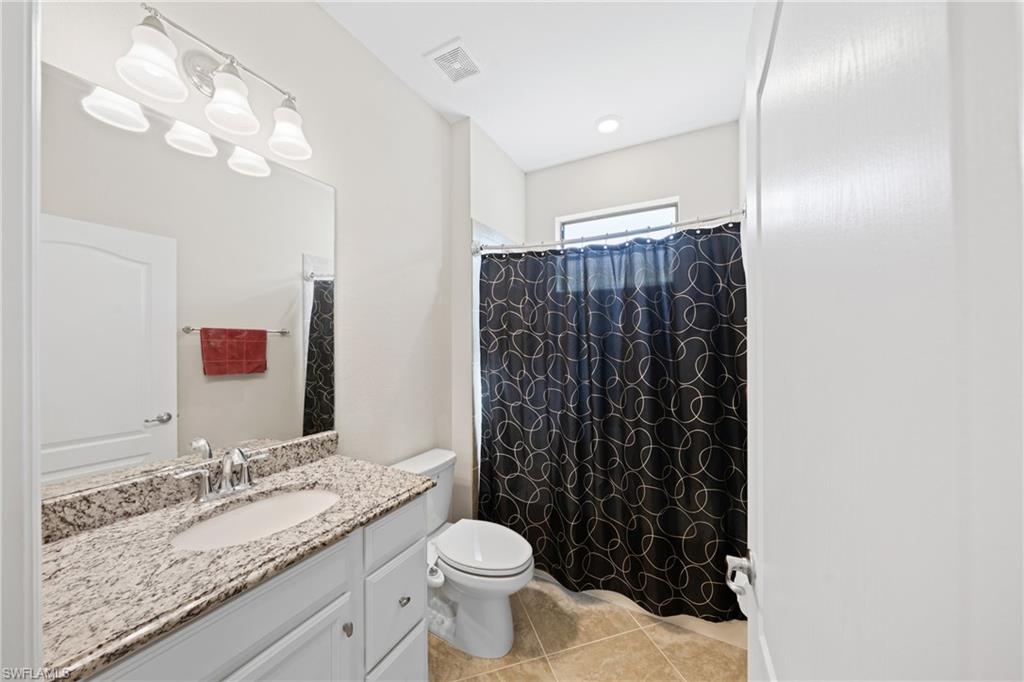 4228 Raffia Palm Circle Naples, FL 34119 - Photo 22 of 50 Full bath with vanity, light tile patterned floors, and a shower with curtain