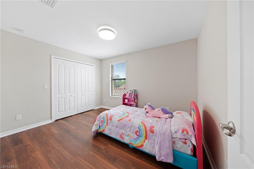 4228 Raffia Palm Circle Naples, FL 34119 - Photo 24 of 50 Bedroom featuring dark wood-type flooring and a closet