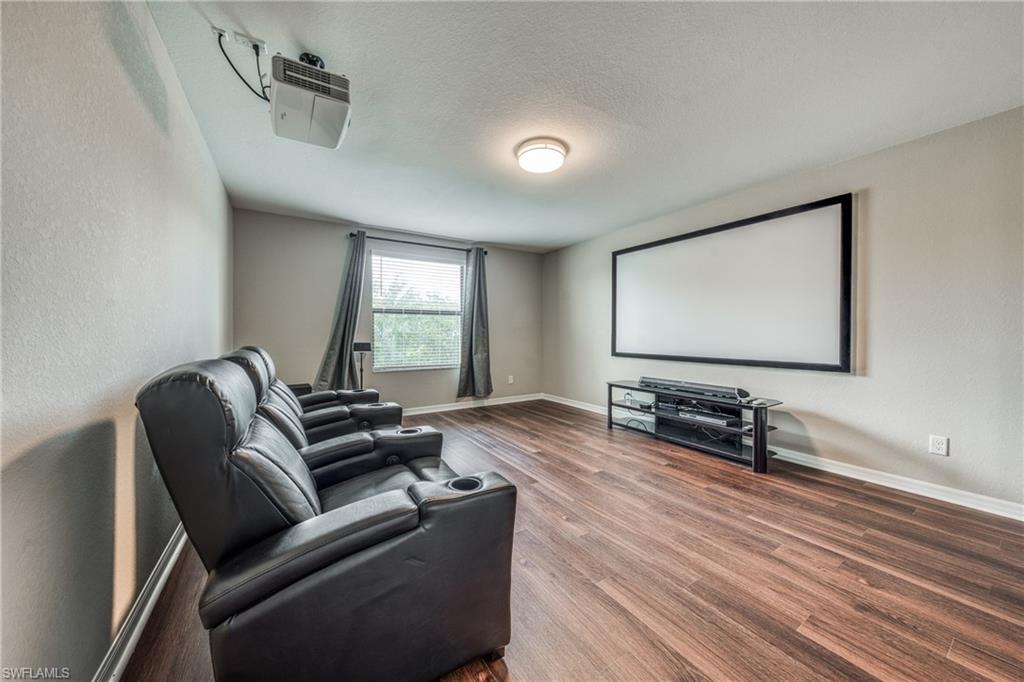 4228 Raffia Palm Circle Naples, FL 34119 - Photo 27 of 50 Cinema room with a textured wall, a textured ceiling, and wood finished floors