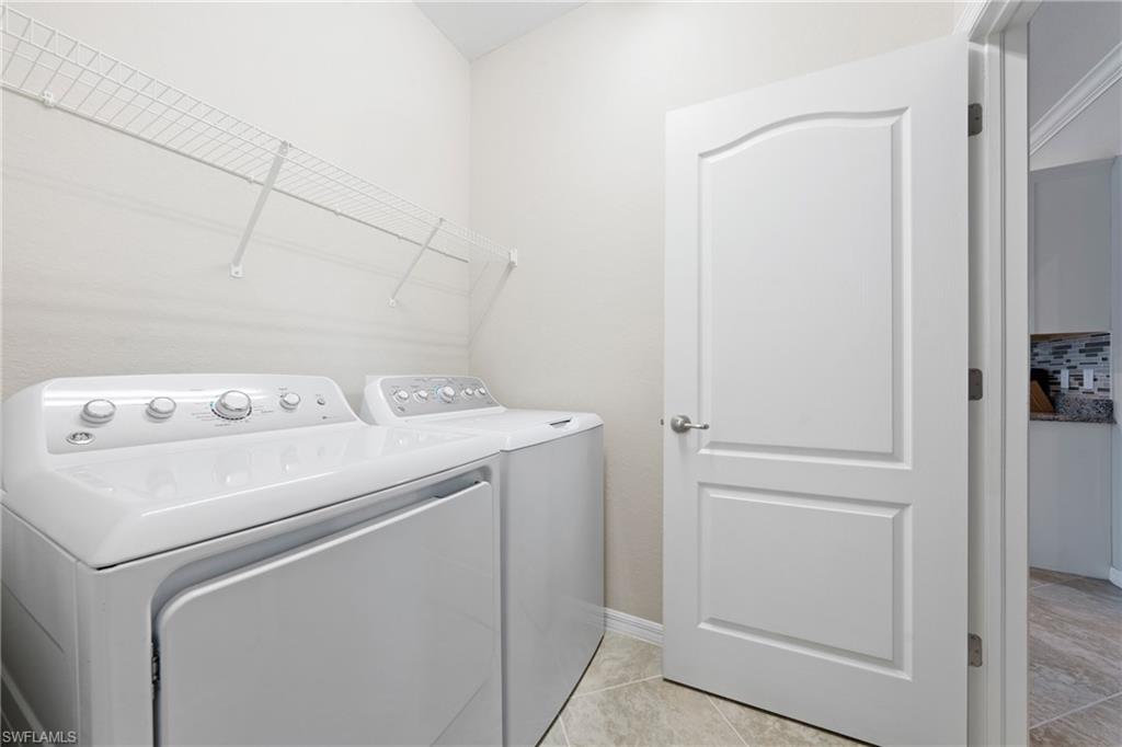 4228 Raffia Palm Circle Naples, FL 34119 - Photo 30 of 50 Washroom featuring light tile patterned floors and washing machine and clothes dryer