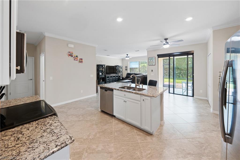 4228 Raffia Palm Circle Naples, FL 34119 - Photo 50 of 50 Kitchen featuring open floor plan, crown molding, light stone countertops, stainless steel appliances, and recessed lighting